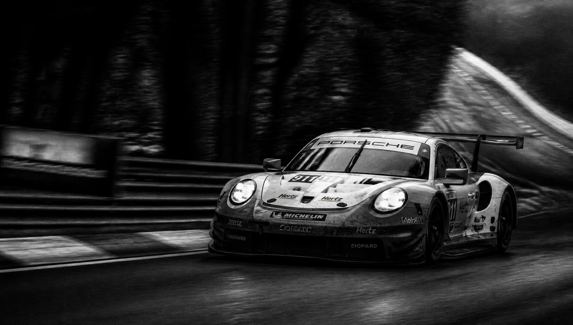GT race car cornering at speed, black and white